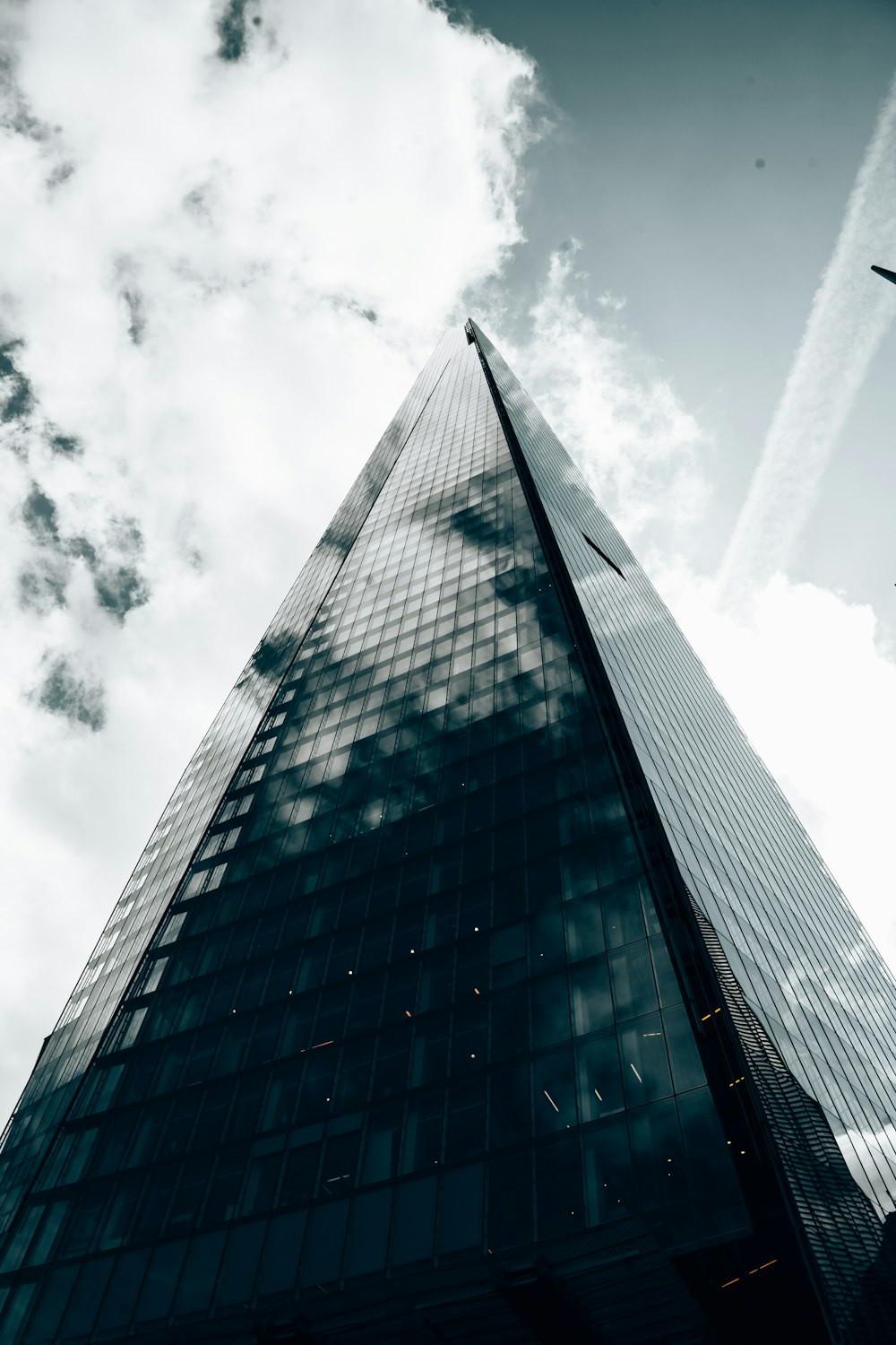 a tall building with clouds in the sky