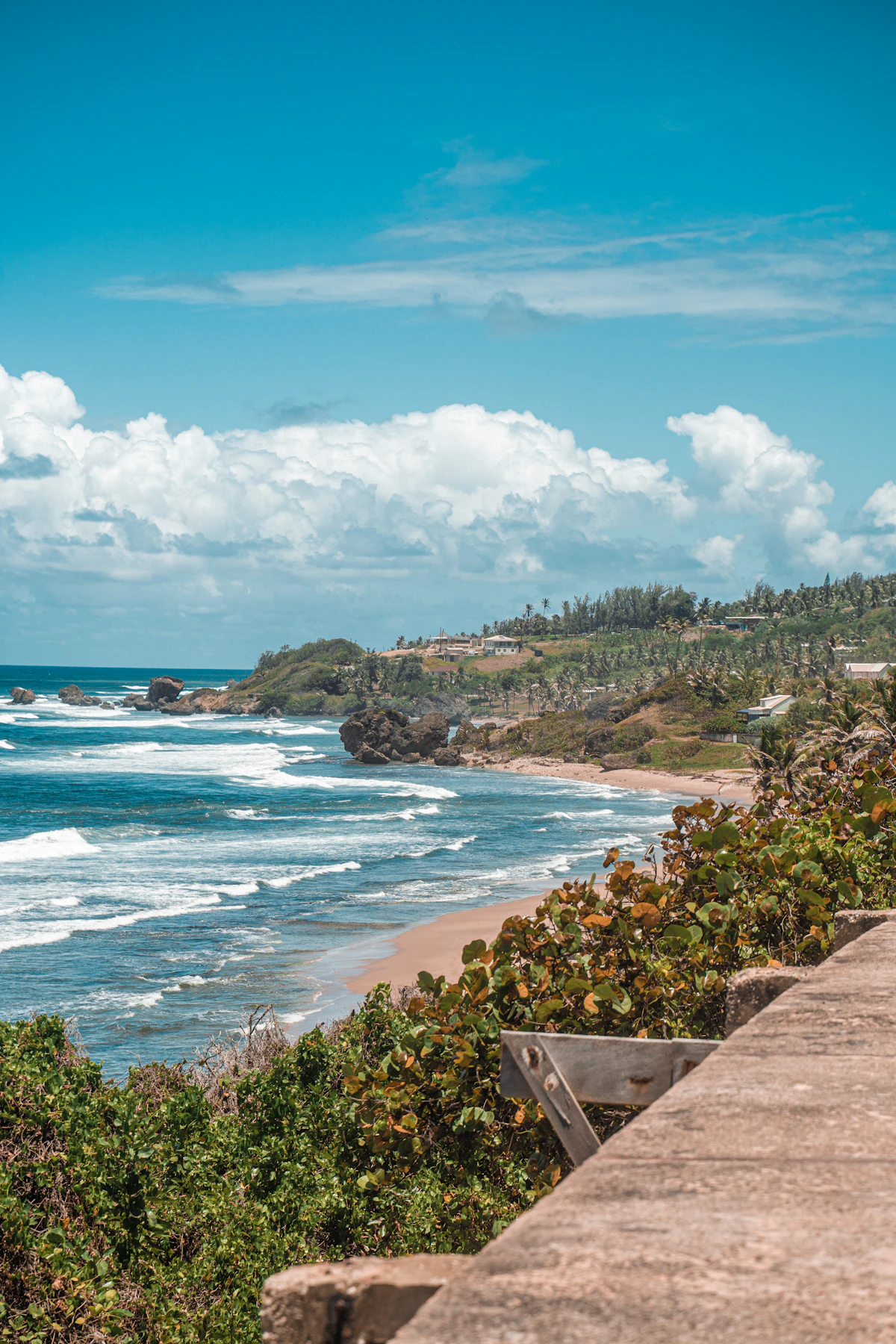 Rugged Atlantic coastline near Bathsheba, Barbados, with waves breaking against volcanic rock formations under a bright sky