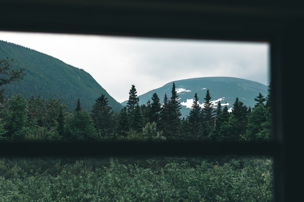 a lake with trees and mountains in the background