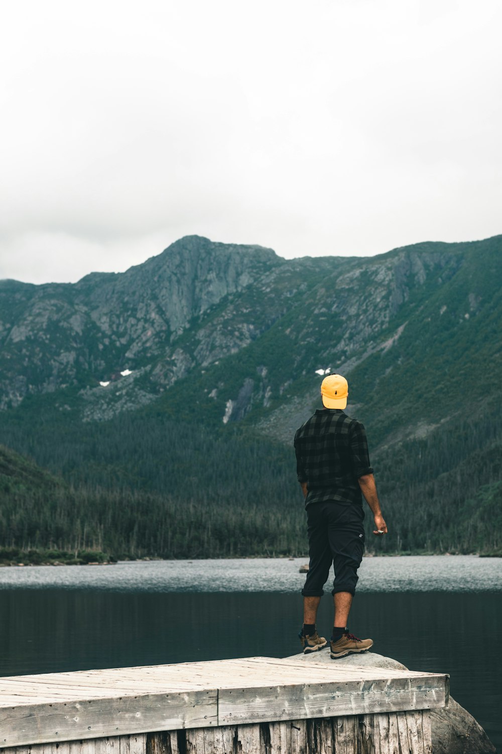 a man standing on a dock looking at a body of water