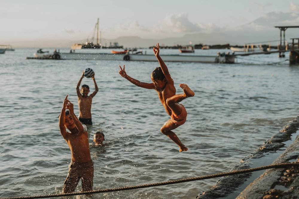 a group of people jumping into the water