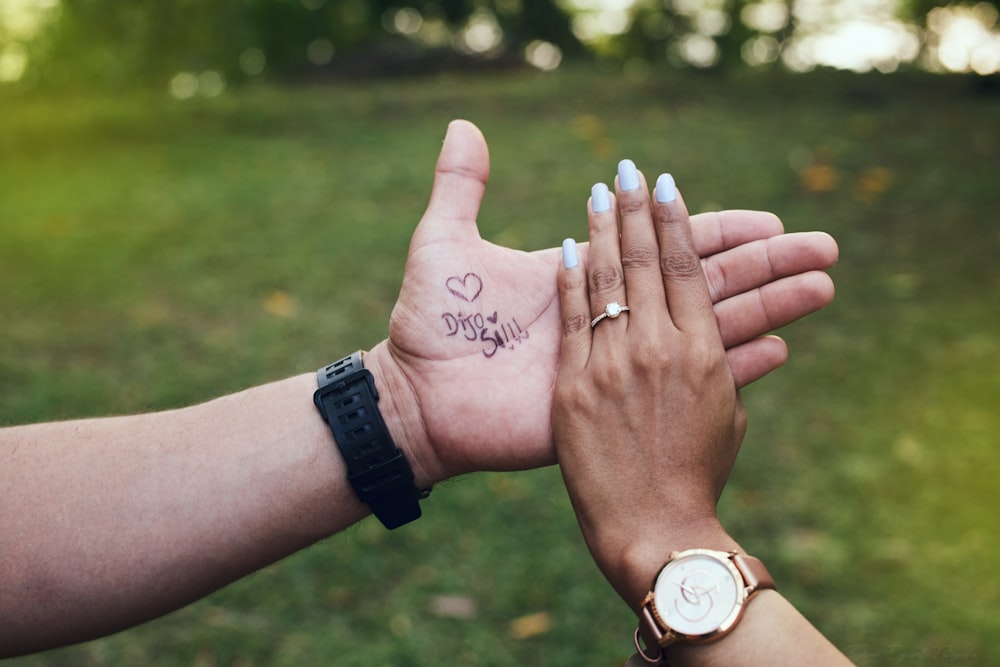 um par de mãos com tatuagens
