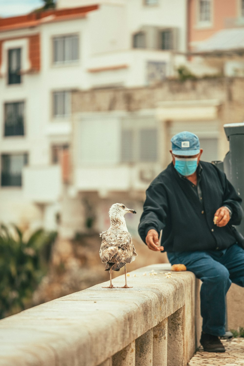 a man sitting on a bench with a bird on his shoulder