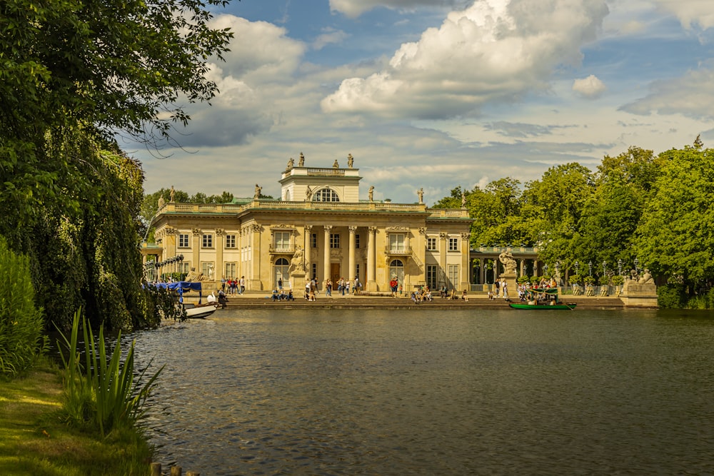 a building with columns and a pond in front of it