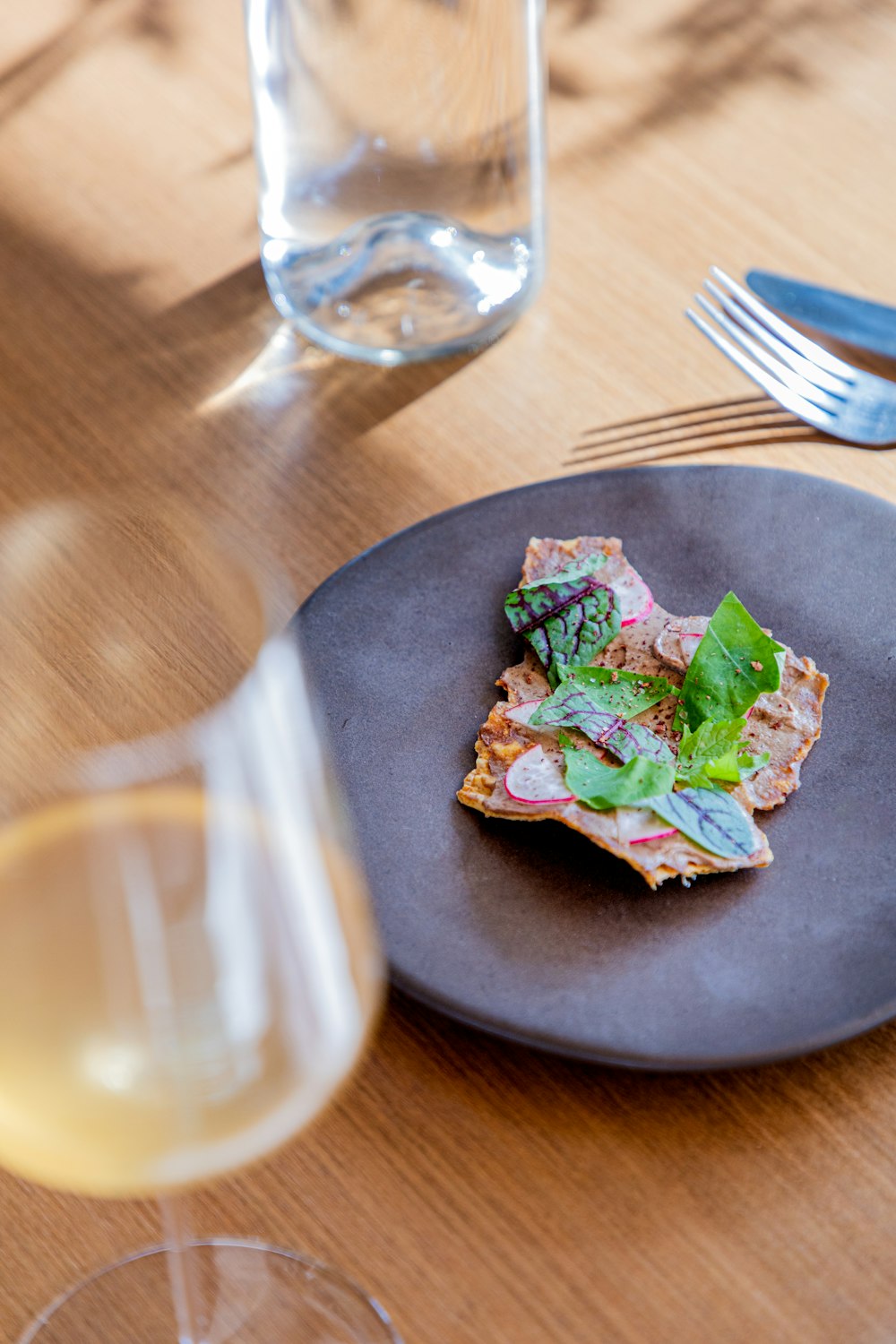 a plate of food and a glass of wine on a table