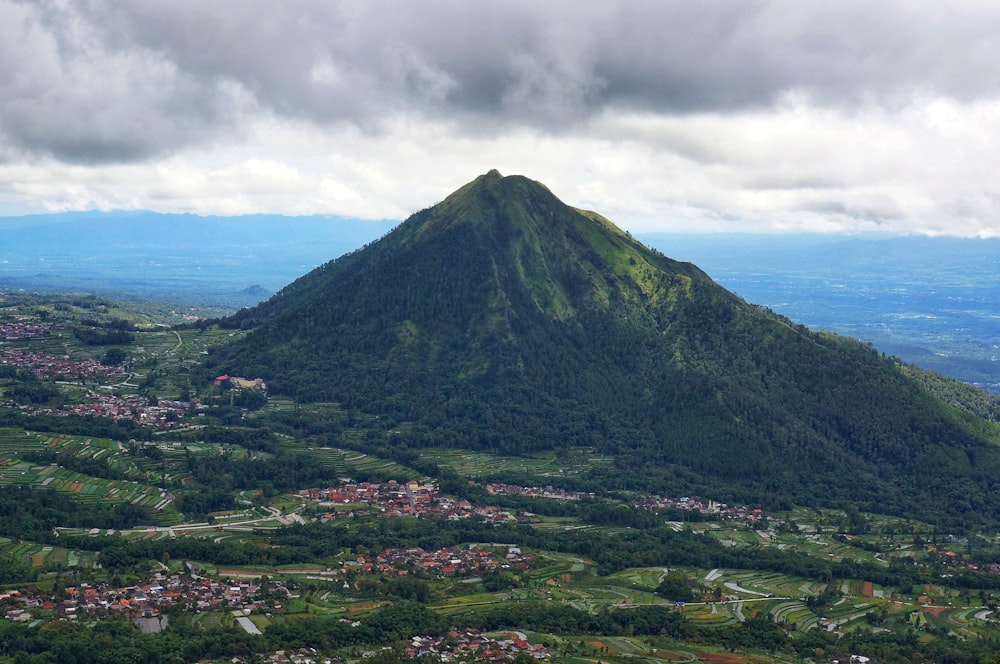 a green mountain with a town below