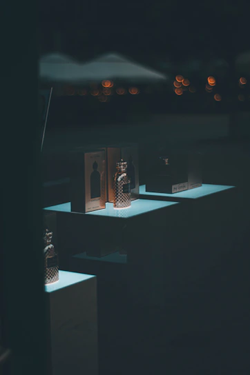 A beautifully arranged display of elegant perfume bottles with soft lighting highlighting their colors and shapes.