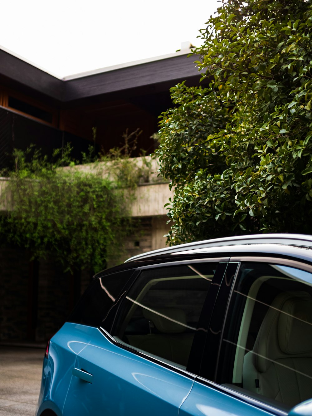 a blue car parked in front of a house