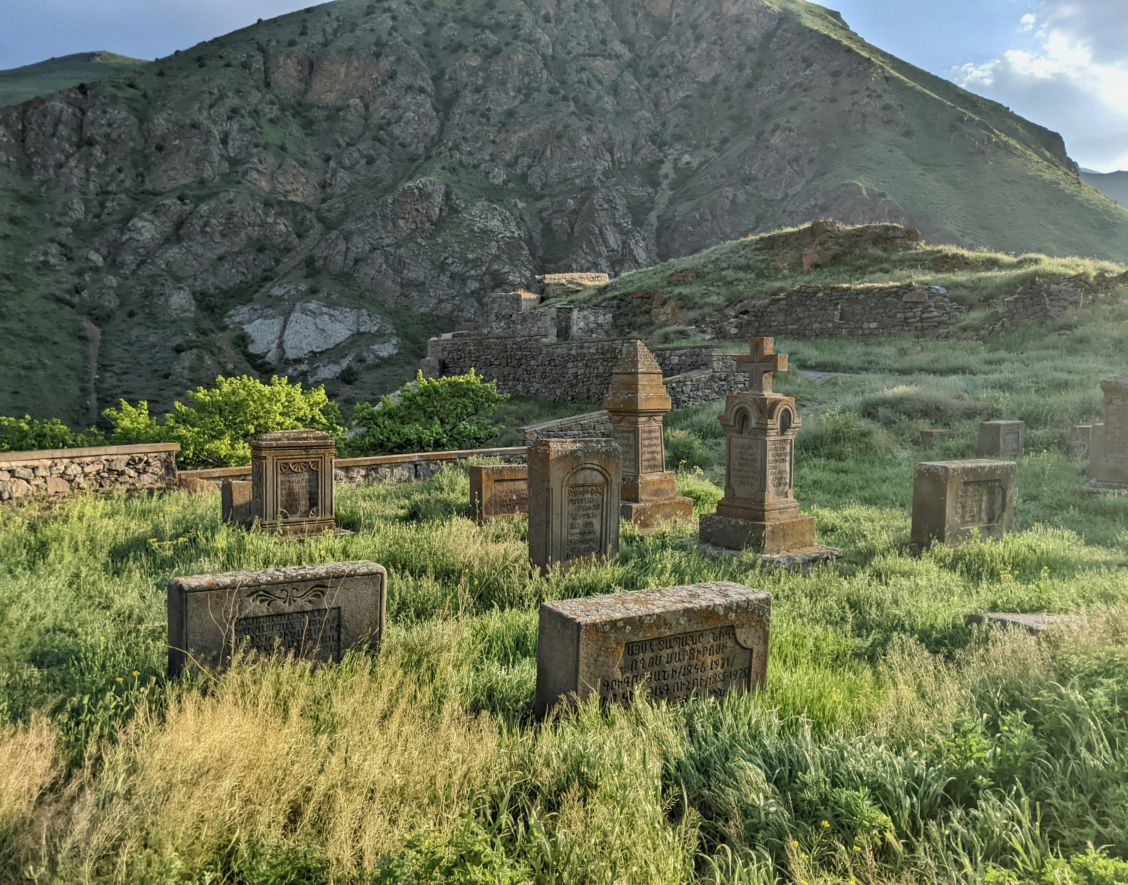 Structure en pierre ancienne dans une prairie verdoyante avec une montagne en arrière-plan