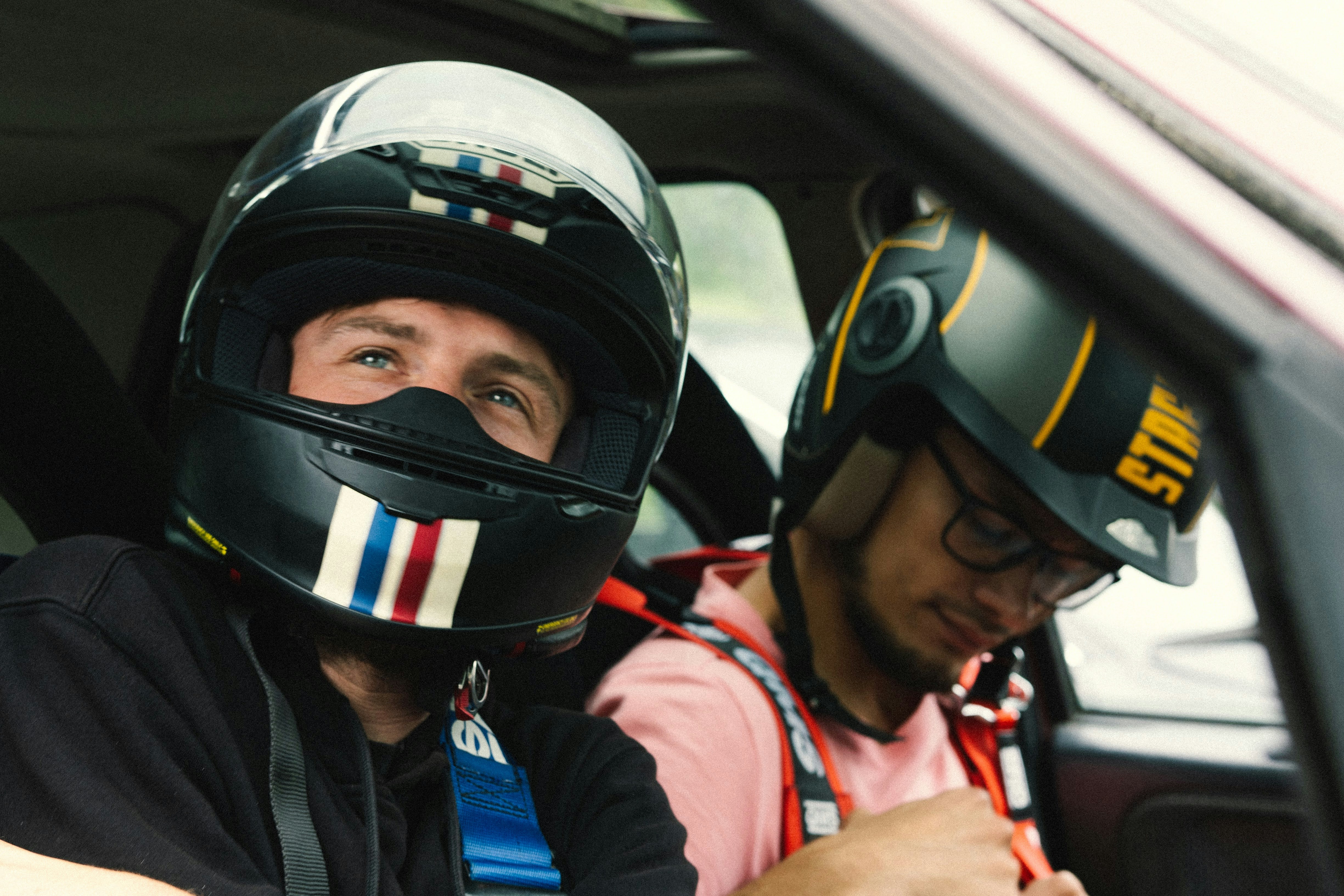 A safety campaign poster depicting a family buckling up in a car and a motorcyclist wearing a helmet, with text promoting safe driving, traffic rule adherence, and the value of life.
