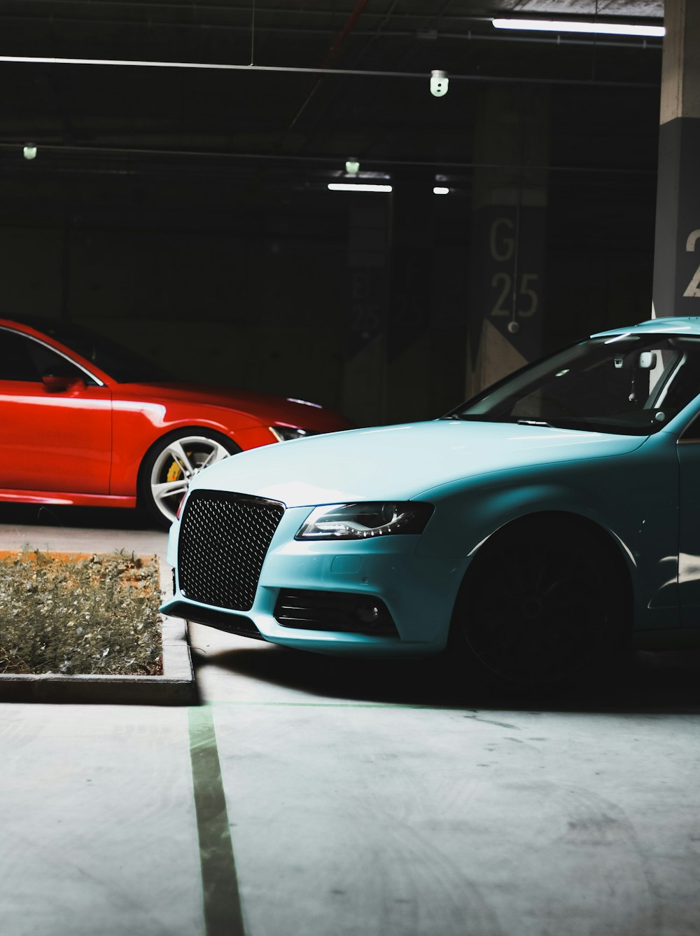 a blue car parked next to a red car