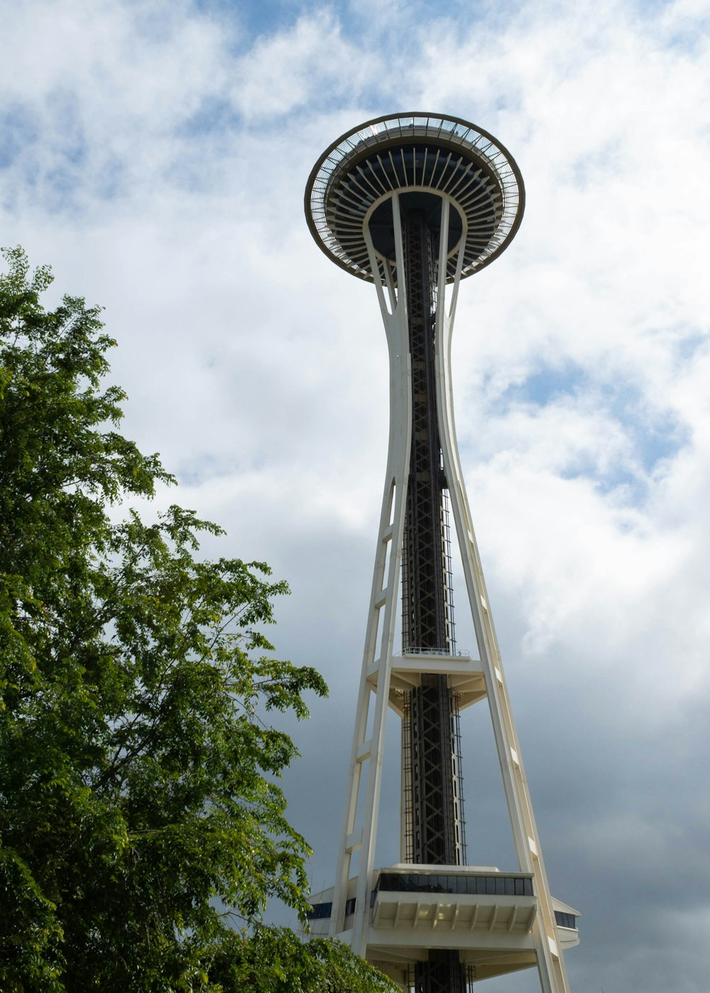 a tall metal tower with Space Needle in the background