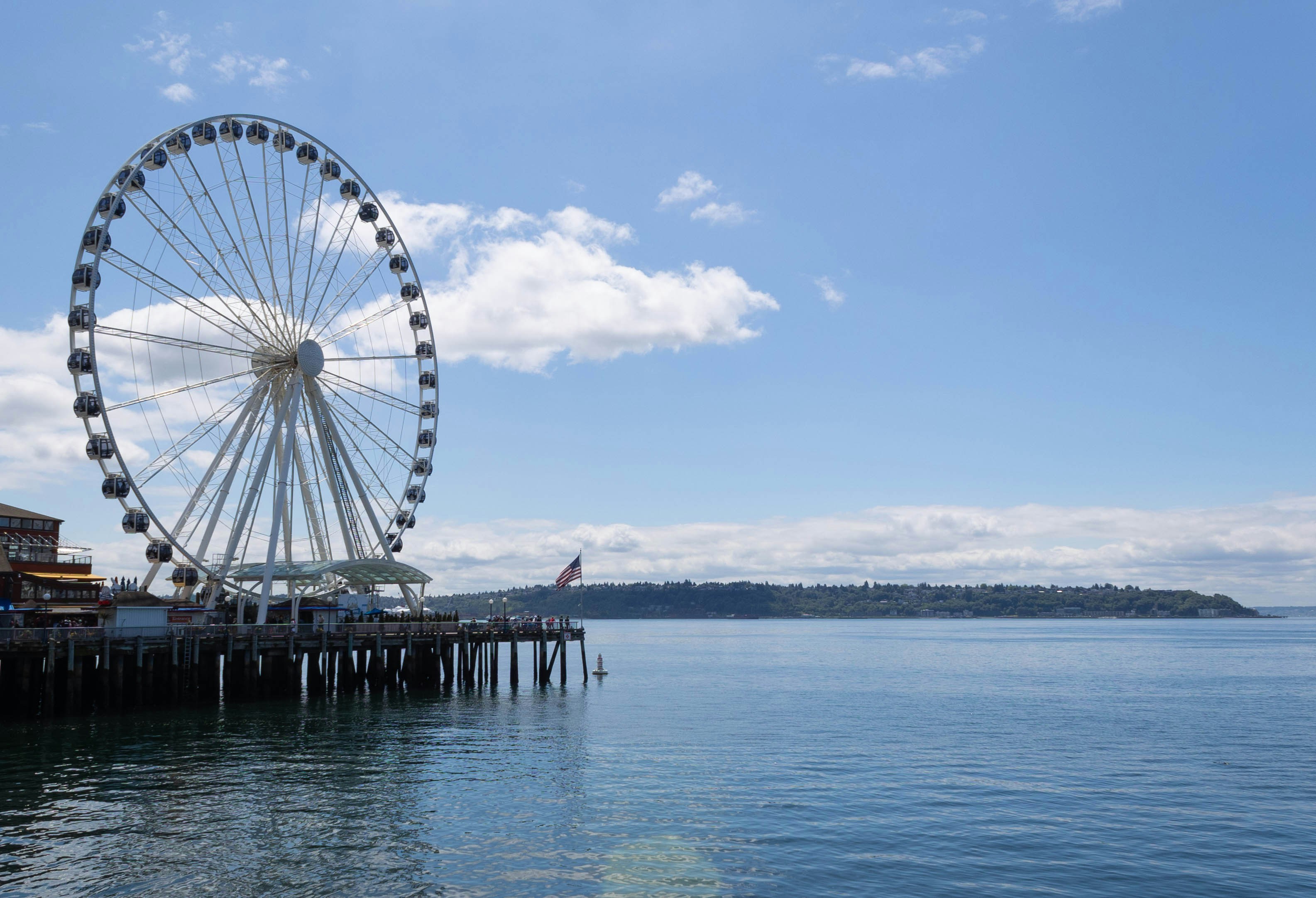 a ferris wheel by a body of water, 