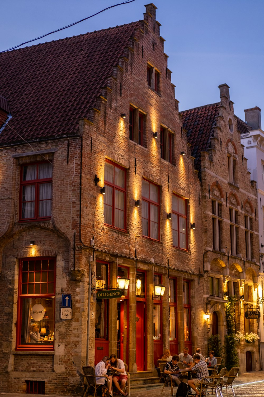 a brick building with people sitting outside