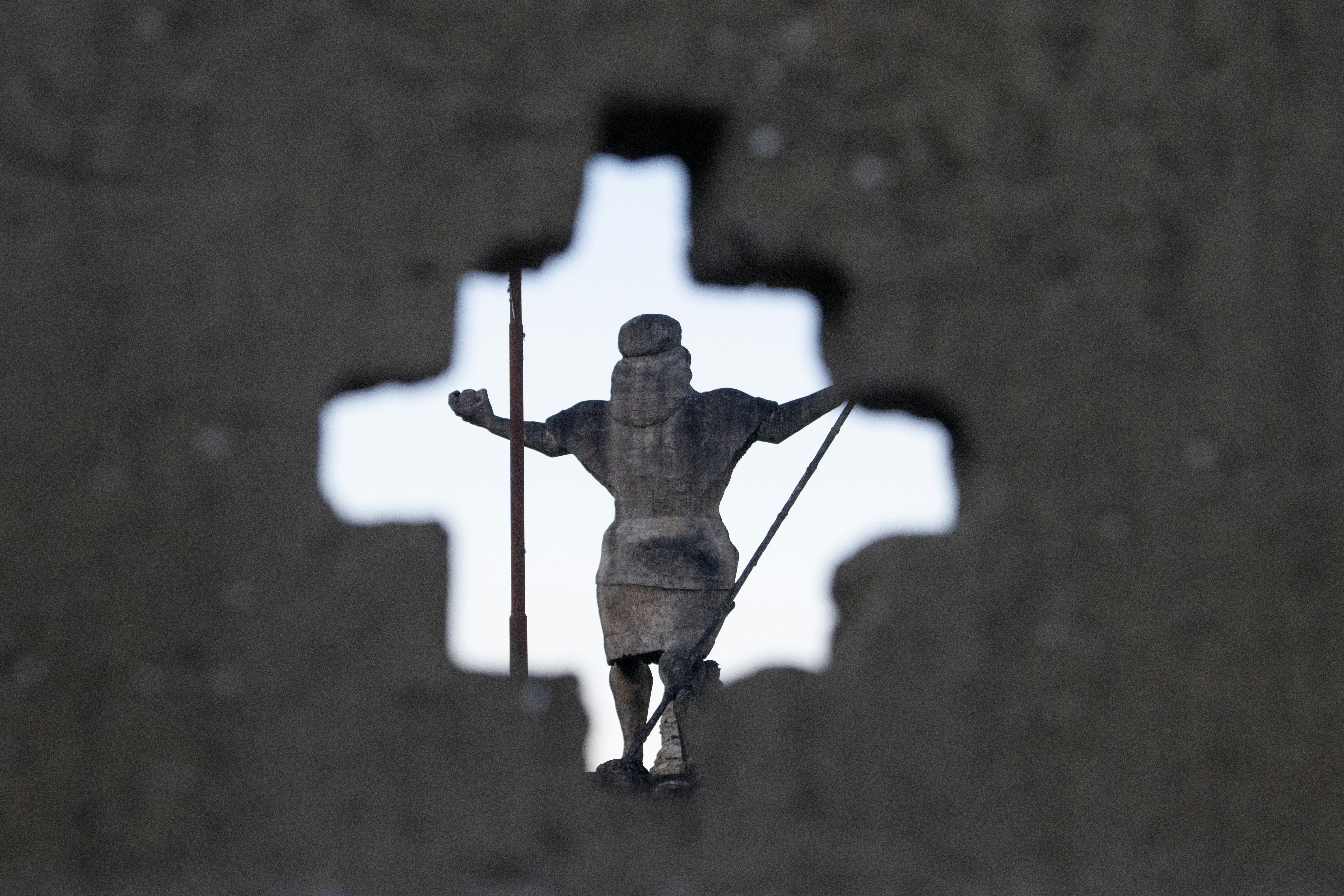 a statue of a person holding a cross