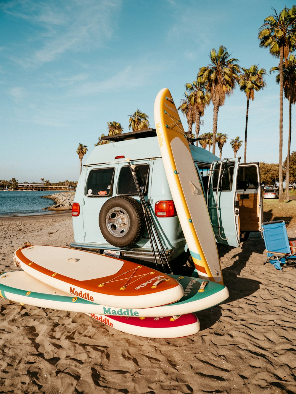 une camionnette avec des planches de surf sur la plage