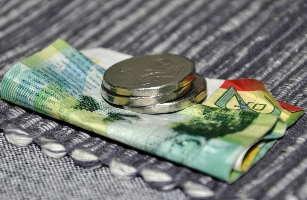 a silver ring on a stack of money