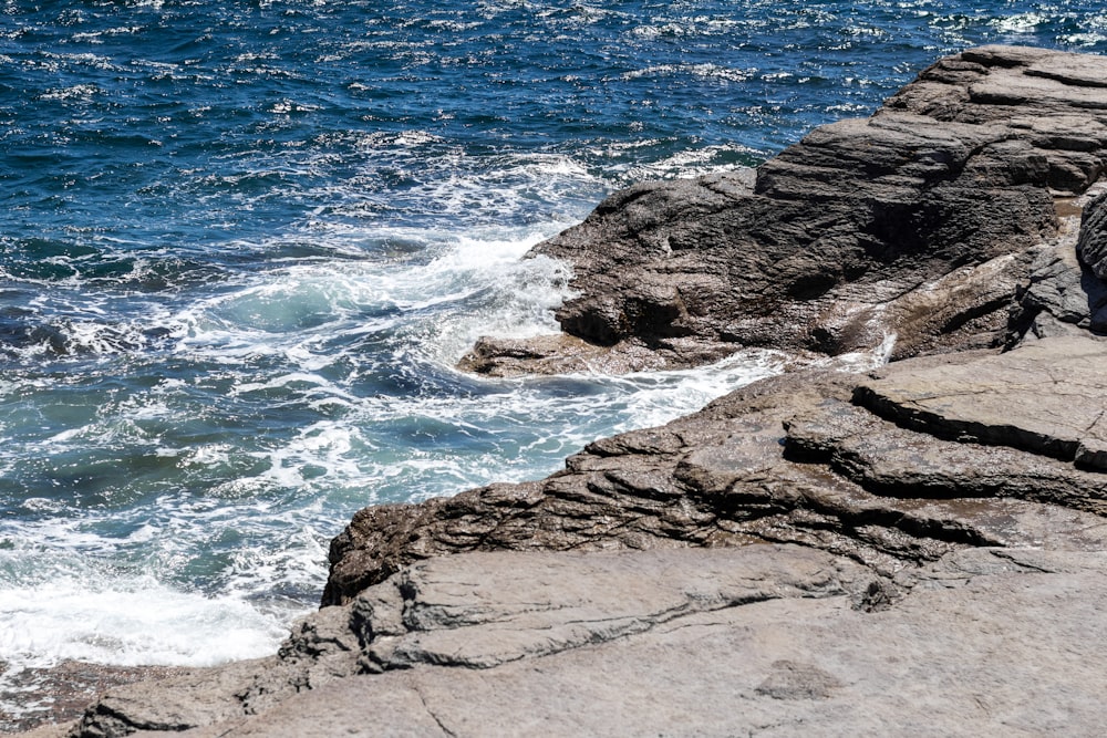 a rocky beach with waves crashing against it