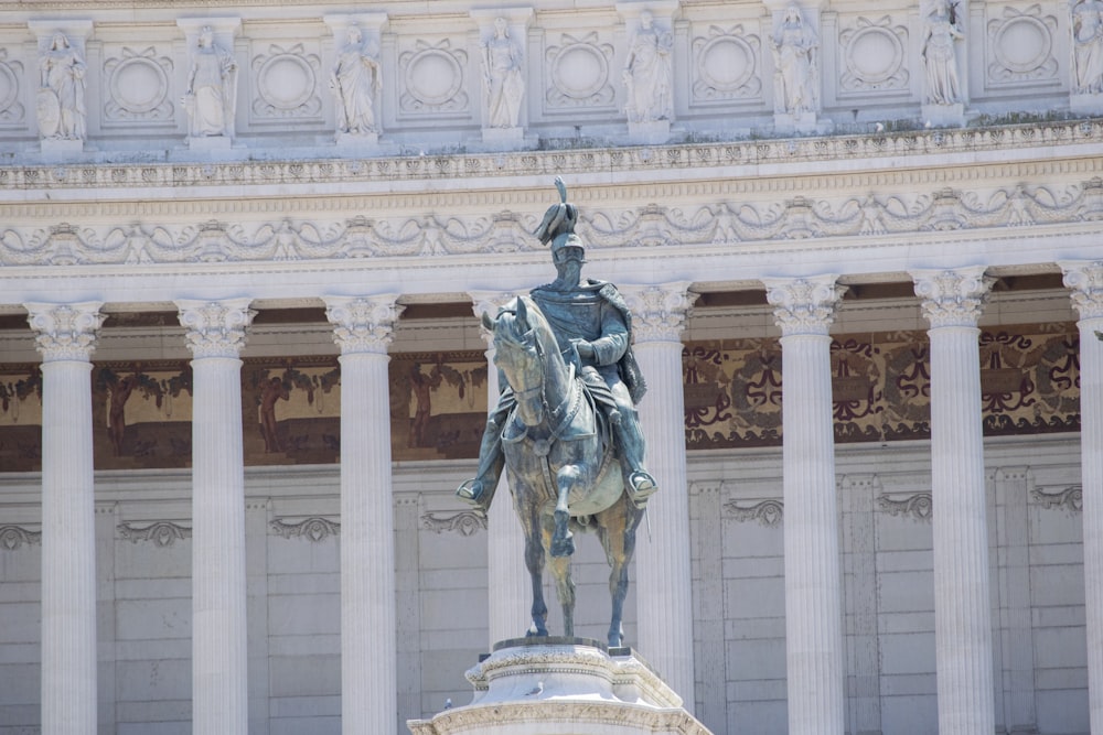 a statue of a person on a horse in front of a building