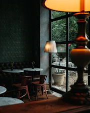 Cozy bistro interior featuring beige marble, black and dark brown accents, and soft warm lighting.