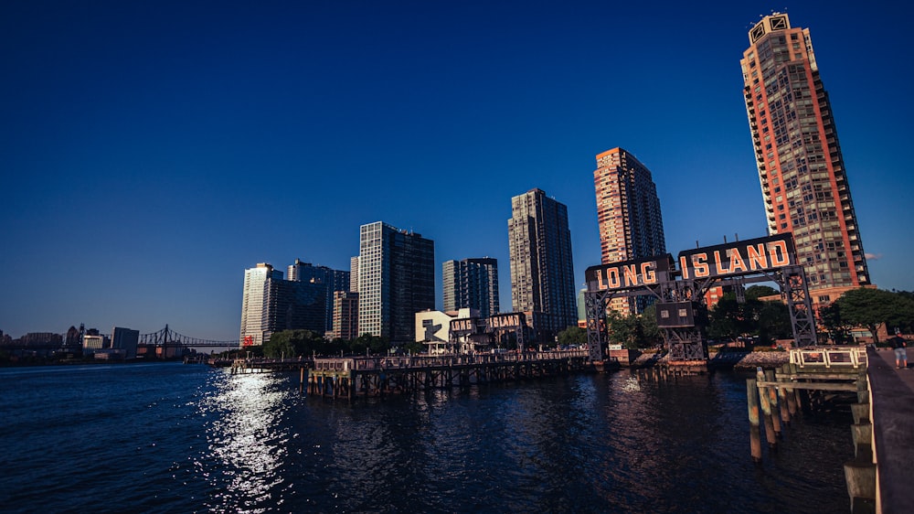 a city skyline with a body of water in front of it