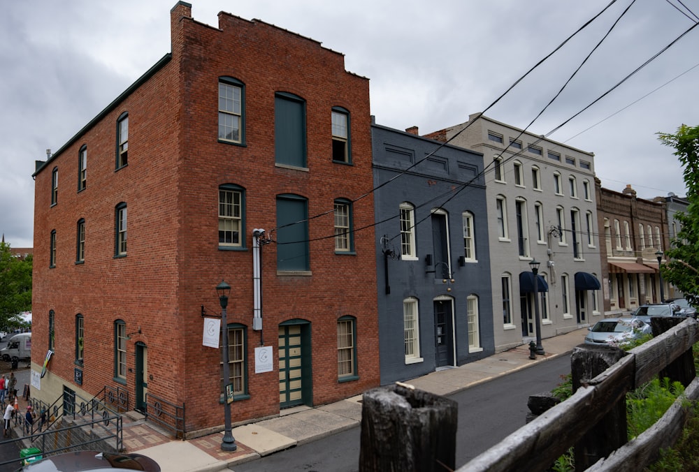 a brick building with a street and cars parked in front