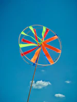 Playful windspinner mockups spinning gently outdoors with a sunny sky background.