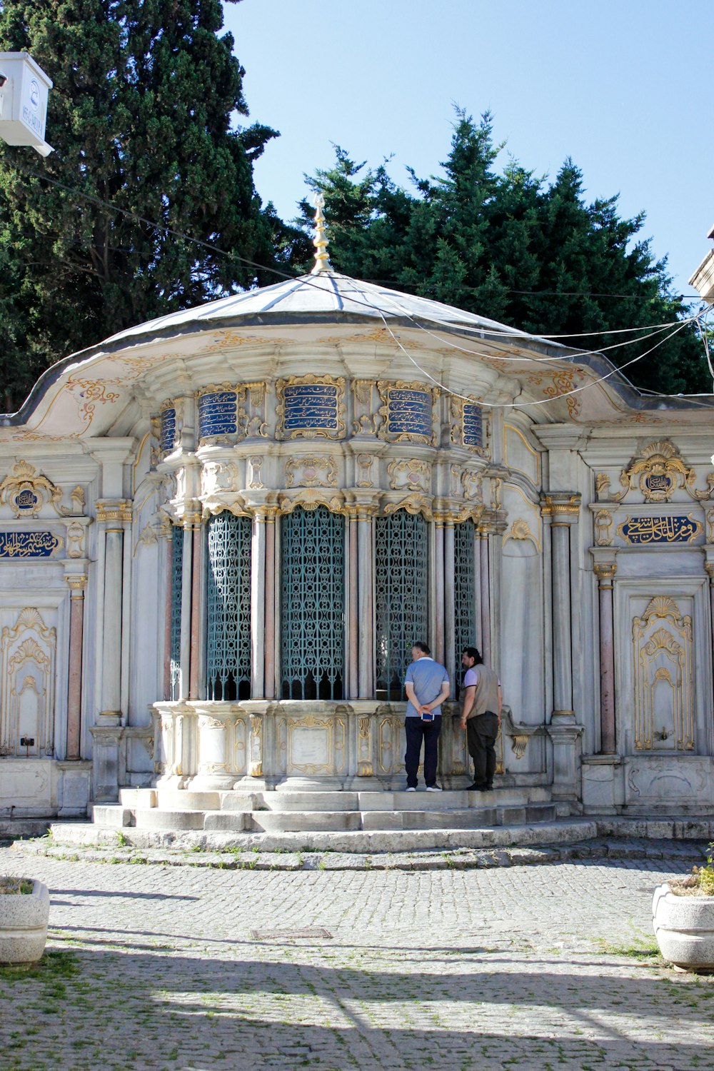 a couple of people standing in front of a building with a large glass roof