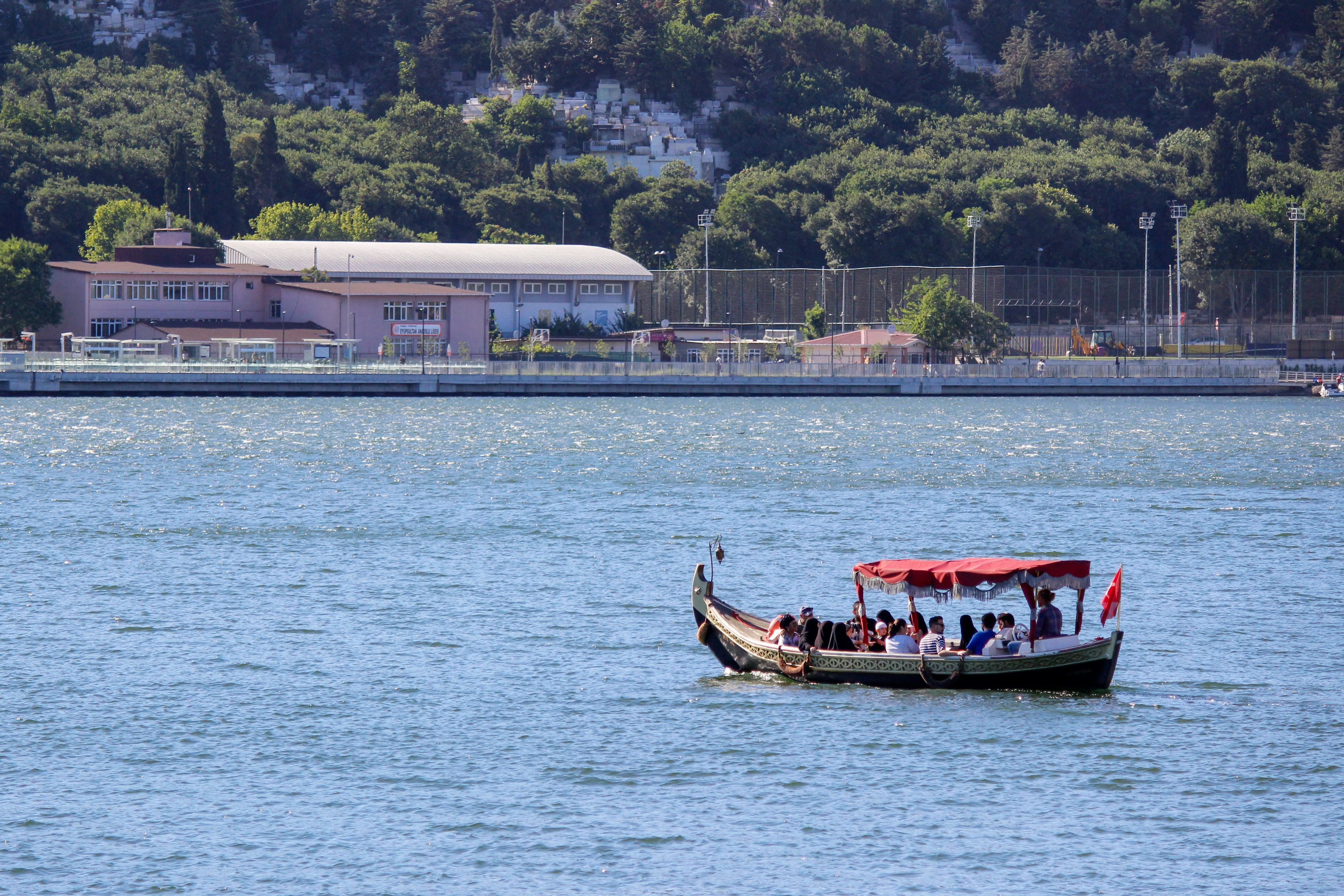 A boat full of people sailing on the water photo – Free Grey Image on ...