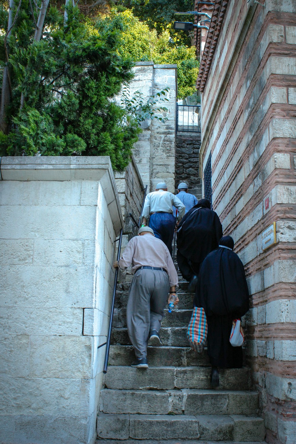 people walking up a stone staircase