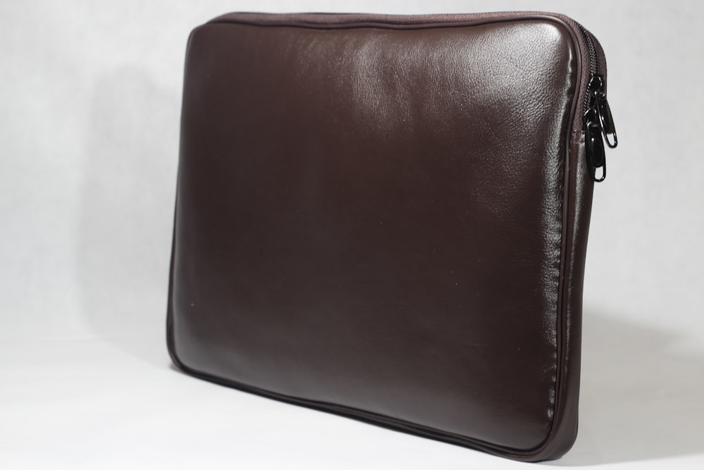 a leather bag on a white surface