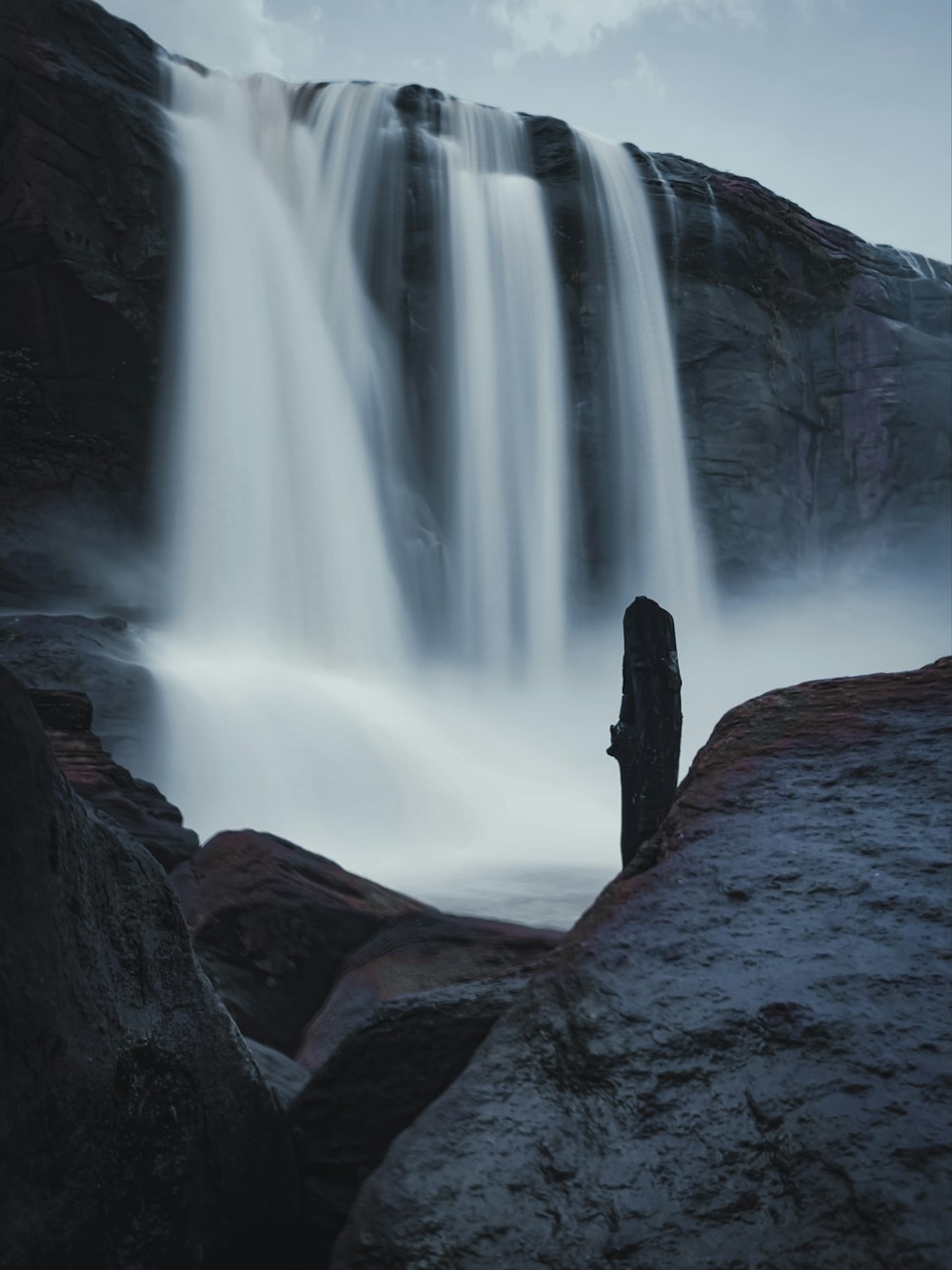 a waterfall with a rock wall