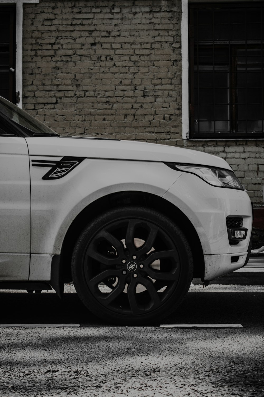 a white car parked in front of a brick building