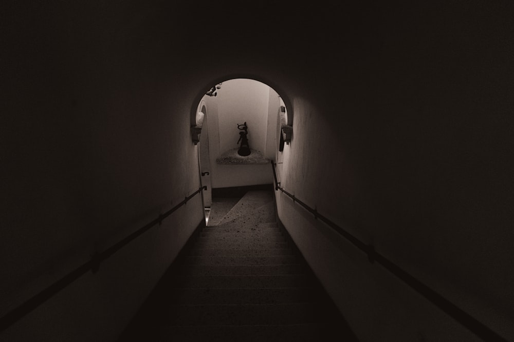 a dark hallway with a light on the end