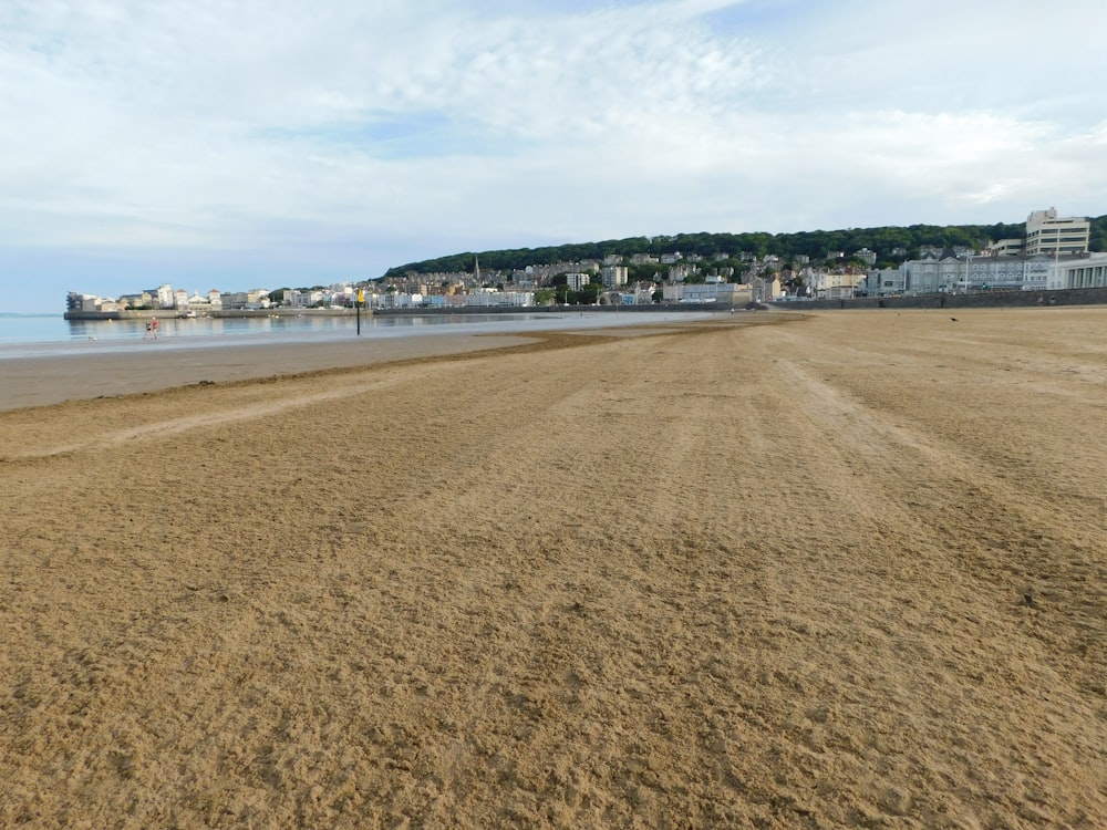 a sandy beach with buildings in the background