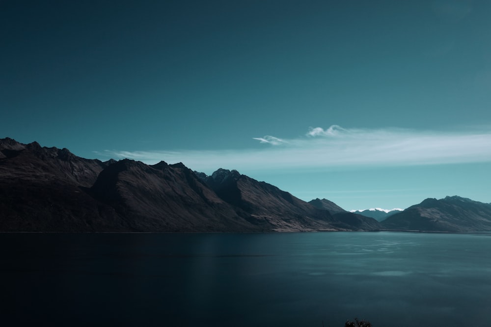 a body of water with mountains in the background