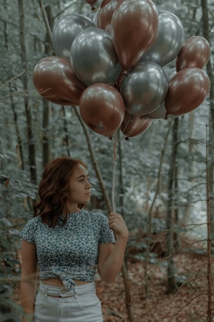 a person holding a bunch of balloons