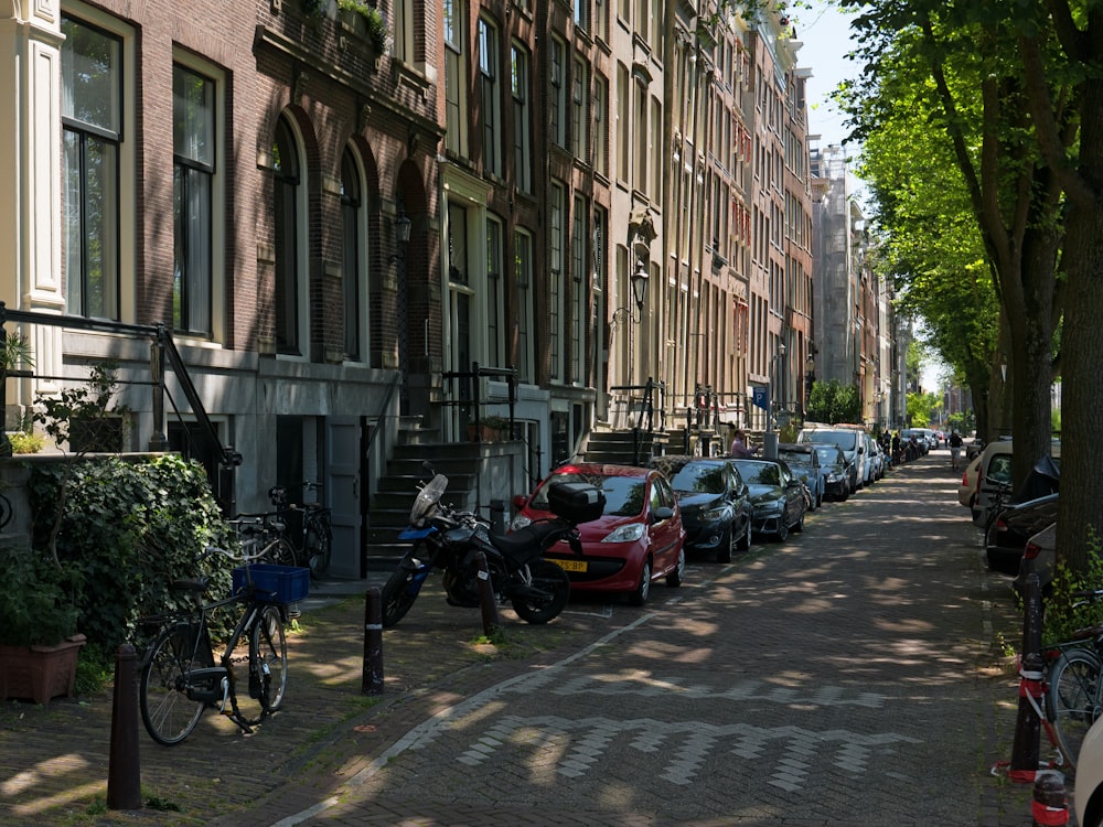 uma rua com carros e motocicletas estacionados ao lado