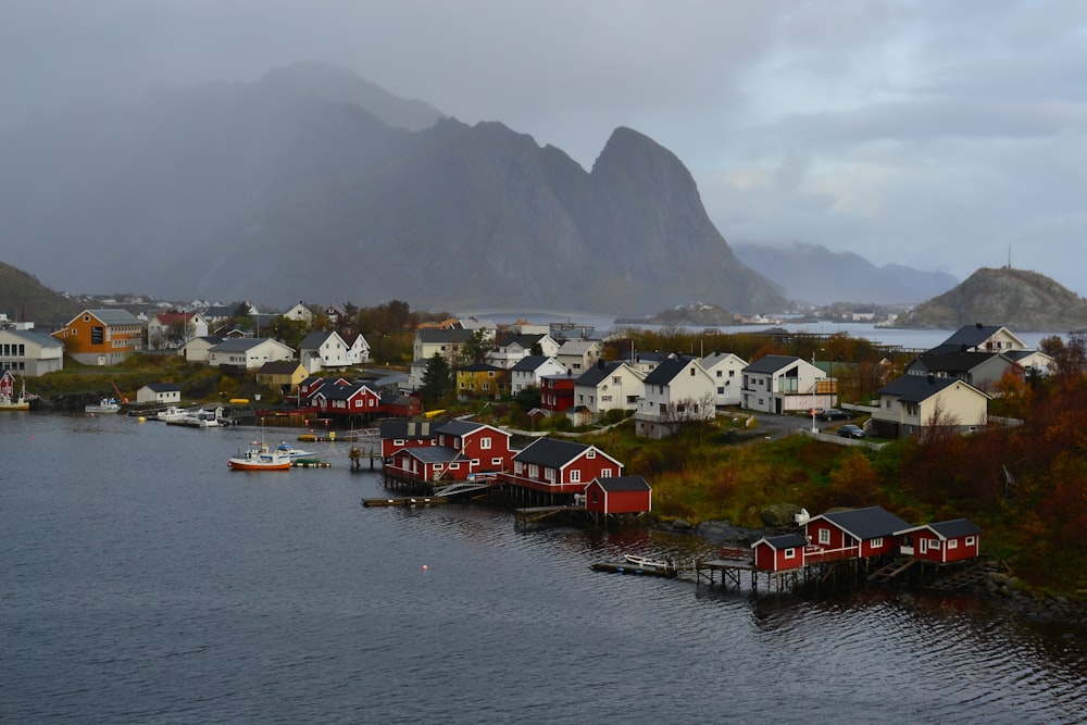 a town next to a body of water with Lofoten in the background
