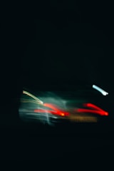 Motion-blurred abstract image of a supercar silhouette with fiery red and yellow highlights.