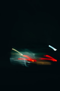 Motion-blurred abstract image of a supercar silhouette with fiery red and yellow highlights.