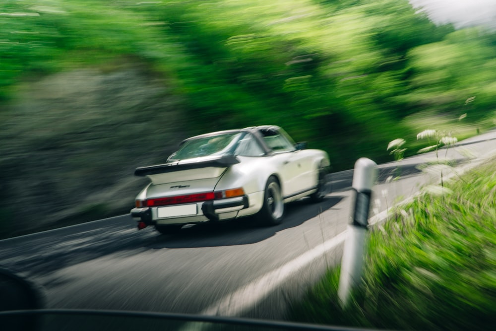 a white car driving on a road