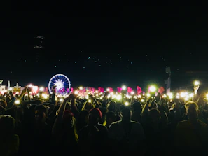 A panoramic shot of a nighttime event with fans cheering under cinematic lighting effects