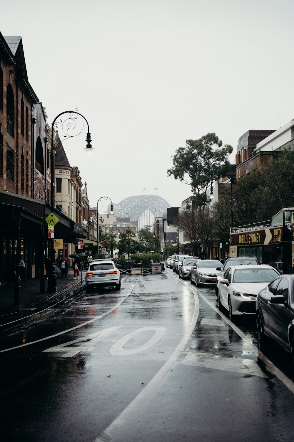 a wet street with cars and buildings