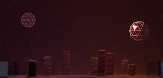 A surreal scene featuring geometric shapes and patterns. Two spheres hover above a series of tall, column-like structures with swirling designs. The backdrop is a dark, textured surface adding depth to the composition.