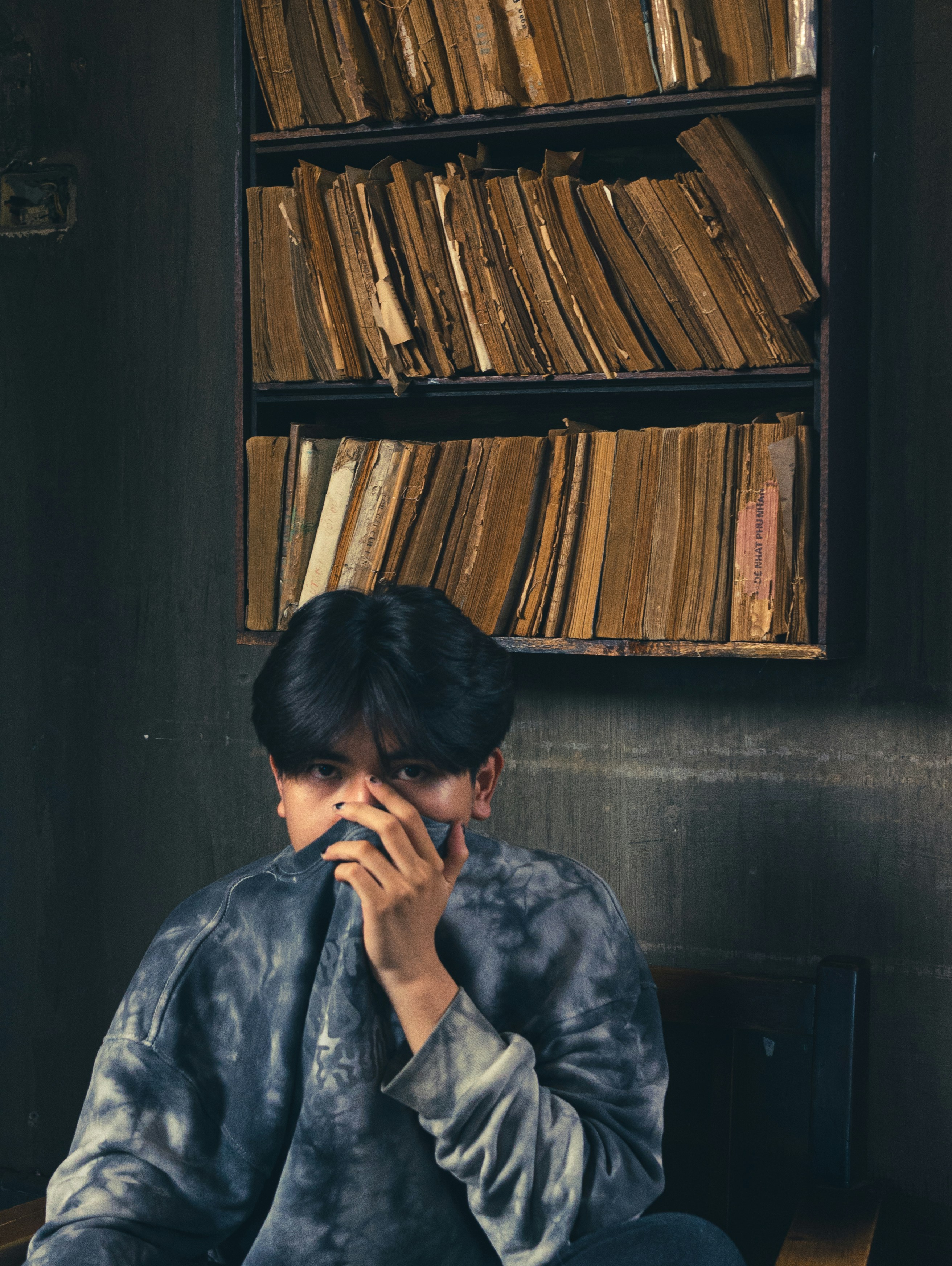 a man sitting in front of a book shelf