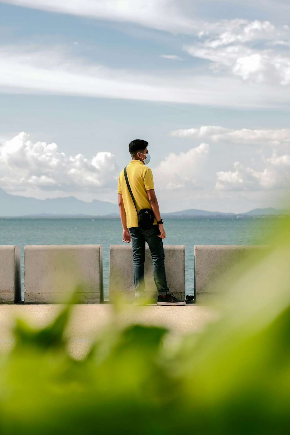 a man standing on a ledge overlooking the ocean