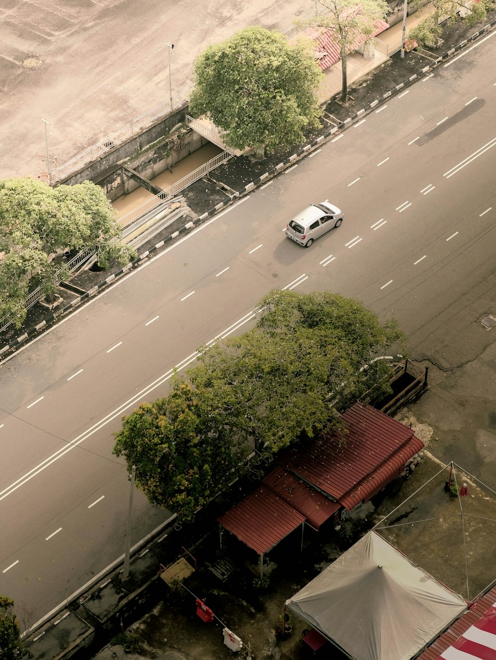 a street with a car and trees