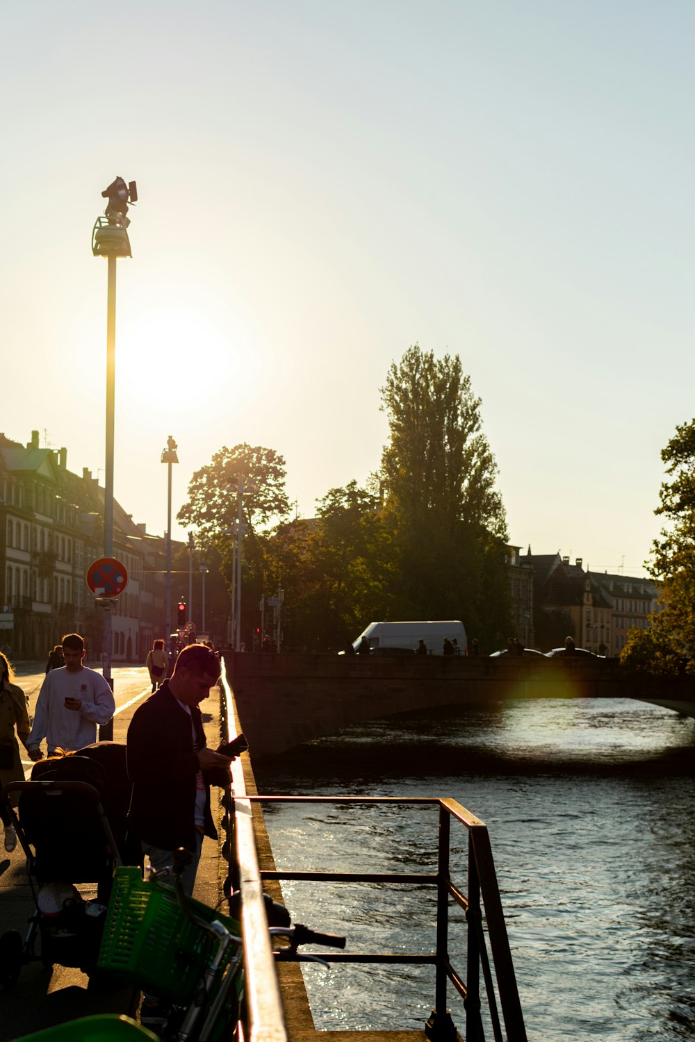 a group of people sitting on a bench by a river