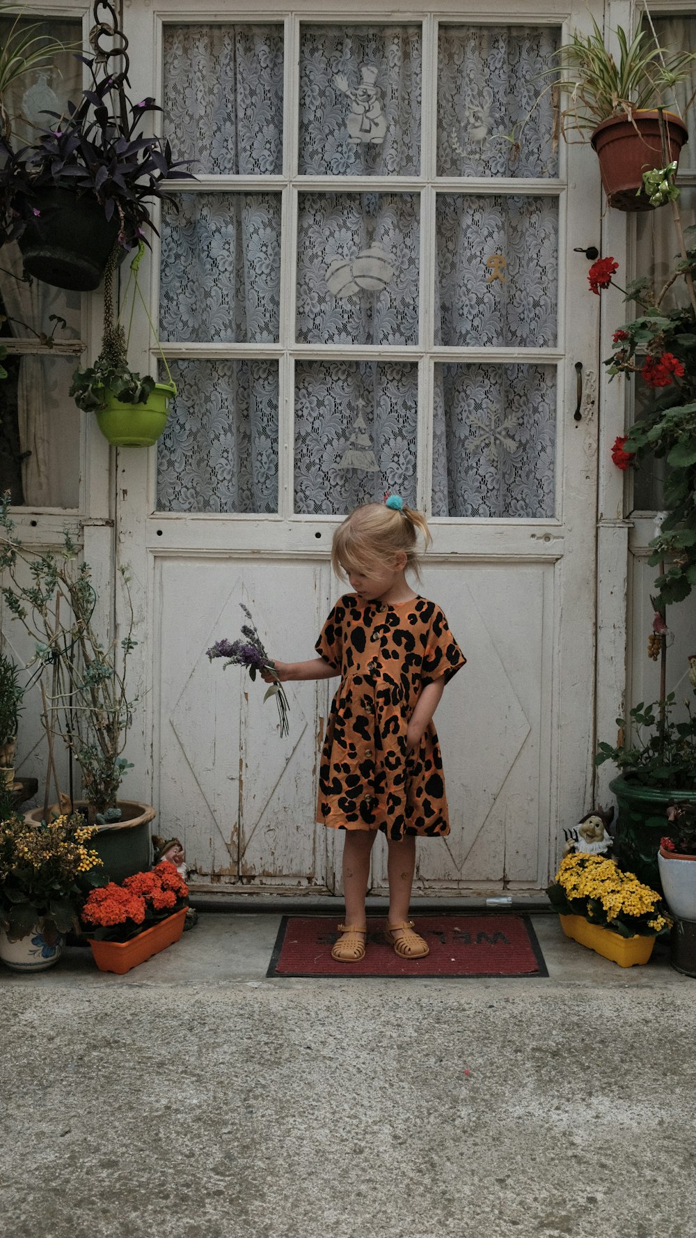 uma menina em pé na frente de uma janela